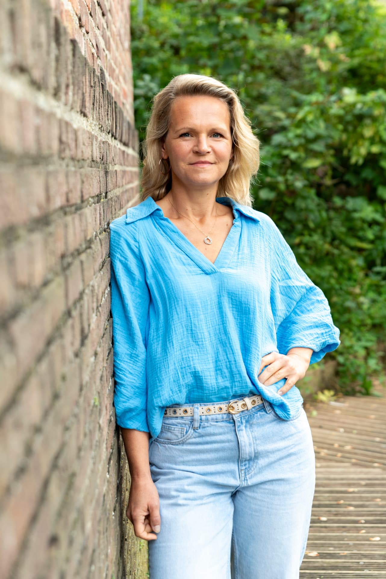 Esther van Krieken leunt ontspannen tegen een muur